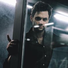 a man standing in front of a mirror giving the peace sign with his right hand