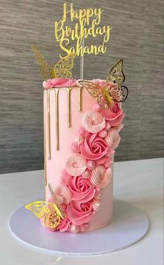 a pink birthday cake decorated with flowers and butterflies