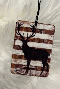 a wooden ornament with a deer on it's head and stripes in the background