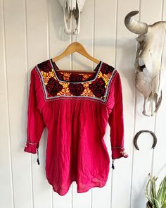 Vintage Red Embroidered Butterfly and Flower Flowing Blouse. No tags. 3/4 sleeves with ties. Black, yellow, blue, and violet embroidery on red. Length: 28.5" Underarm to underarm: approximately 22".Check out the rest of our shop: https://instagram.com/hollyshopvintage?igshid=OGQ5ZDc2ODk2ZA== https://hollyshopvintage.etsy.com/ Orders over $35 ship for free. Please check out my Instagram for my newest finds: Hollyshopvintage  Everything priced over $35 has shipping already included in the total price. I'll gladly combine shipping on multiple items to save you money, when it is safe to do so! Message me to make adjustments ahead of time, or make your purchase and I'll refund the shipping overages.  Most items are Vintage. Expect some vintage wear. Items may contain unmentioned flaws.  I only Red Tunic Blouse For Summer, Red Half Sleeve Summer Blouse, Red 3/4 Sleeve Summer Top, Red 3/4 Sleeve Top For Summer, Red 3/4 Sleeve Summer Blouse, Bohemian Tops With 3/4 Sleeve And Floral Embroidery, Red Tunic Blouse For Festival, Red Long Sleeve Beach Blouse, Red Long Sleeve Cotton Embroidered Top