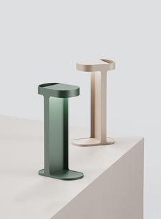 two different colored pedestals sitting on top of a white table next to each other