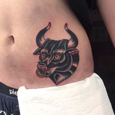 a bull tattoo on the side of a woman's stomach