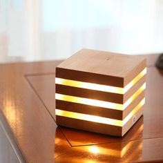 a wooden box with some lights on it sitting on a table next to a computer mouse