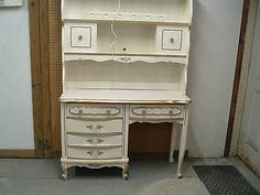 an antique white desk with drawers and shelves