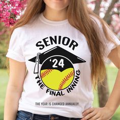 a woman wearing a t - shirt that says senior the final thing, and has a baseball in it