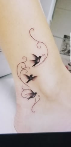 a woman's foot with birds on it and swirls in the shape of hearts