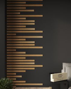 a living room with black walls and wooden slats on the wall, along with a plant