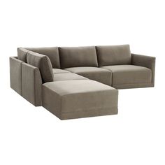 a large sectional couch sitting next to a footstool on top of a white floor