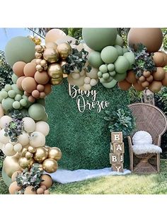 the balloon arch is decorated with gold and green balloons