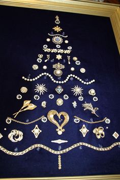 a christmas tree made out of jewelry on display in a gold framed frame with blue velvet