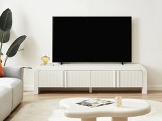 a flat screen tv mounted to the side of a white wall in a living room