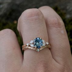 a woman's hand with a blue and white diamond ring on top of it