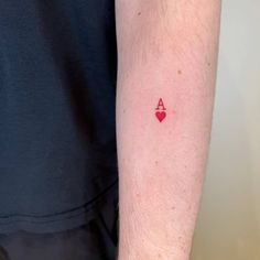 a person with a tattoo on their arm that has a red heart in the middle