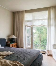 a bedroom with a large bed next to a window