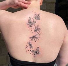 the back of a woman's shoulder with butterflies on it