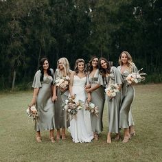 a group of women standing next to each other on top of a lush green field