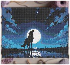 a cross stitch picture of a wolf in the moonlight