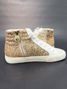 Sparkly sneakers feature a glittered body with star studs along the side, standard lace-up front, grey-colored lace guard, textile interior, distressed rubber soles with arrow shapes, and side zipper. -Sole measures 1" -Non-skid sole --Extra pair of laces in white Sparkly Sneakers, Textile Interior, Vintage Havana, Star Studs, Side Zipper, Lace Up, Zipper, Sneakers, Grey