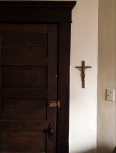 a door with a cross on it and a light switch in front of the door