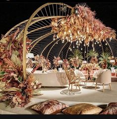 an elaborately decorated table and chairs in a room with flowers on the floor, chandelier above