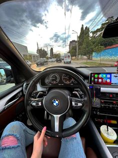 a person is sitting in the driver's seat of a car with their hand on the steering wheel