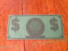 a dollar bill sitting on top of a wooden floor