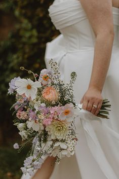 a bride holding a bouquet of flowers in her hand