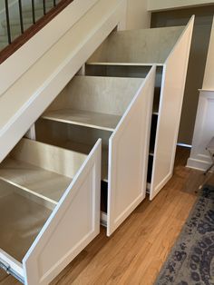 an open cabinet under the stairs in a house