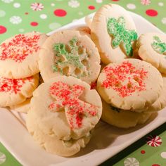 several decorated cookies on a plate with sprinkles