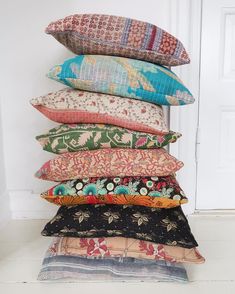 a stack of pillows sitting on top of each other in front of a white door