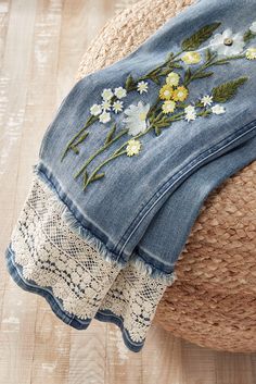 a pair of blue jean shorts with flowers on them