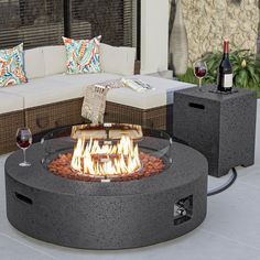 a fire pit sitting in the middle of a living room next to a couch and table