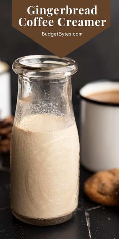 a glass jar filled with coffee creamer sitting on top of a counter next to cookies