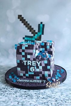 a cake that is made to look like a cube with a knife sticking out of it