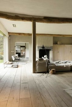 an empty living room with wood floors and large windows