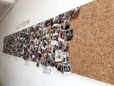 a cork bulletin board with pictures pinned to it on the wall in an office building