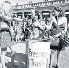 two women are throwing trash into a garbage can while another woman holds her hand out