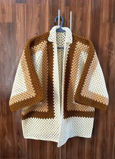 a crocheted jacket hanging on a wooden wall