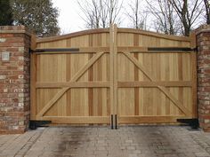 a large wooden gate with brick pillars