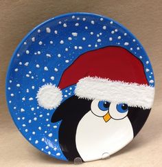 a plate with a penguin wearing a santa hat