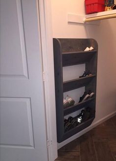 there is a shoe rack in the corner of this closet that has shoes on it