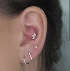 a close up of a person's ear with two piercings on top of it