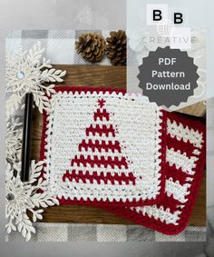 a crocheted christmas tree placemat with snowflakes and pineconis