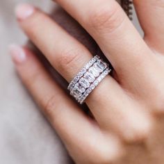 a woman's hand with a diamond ring on her left hand and an engagement band on her right