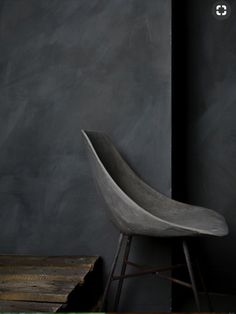 a chair sitting in front of a black wall