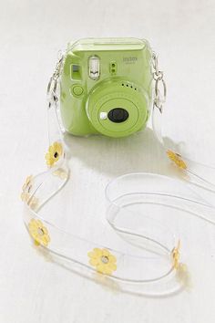 a green camera sitting on top of a white table next to a lanyard strap