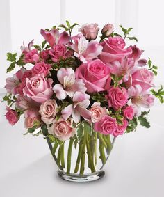 a vase filled with pink flowers on top of a table