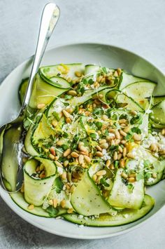 a white bowl filled with cucumbers and nuts