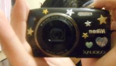 a person taking a photo with a camera in front of their face and stars on the screen