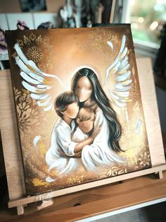 an angel painting on a wooden easel with white wings and a woman holding a child